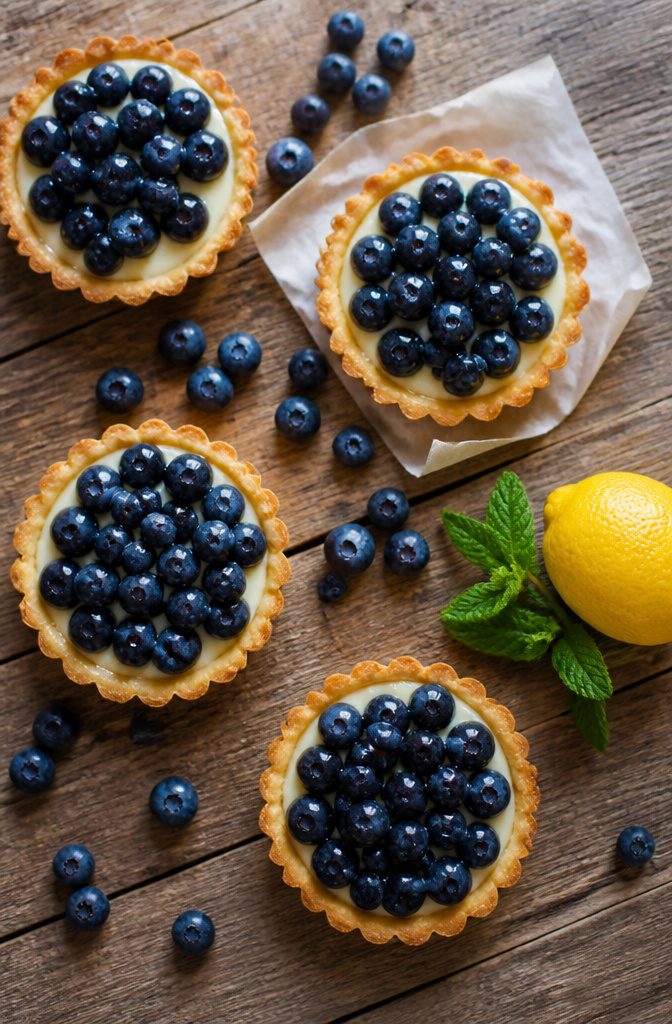 Blueberry tarts with lemon mascarpone cream in a muffin tin.