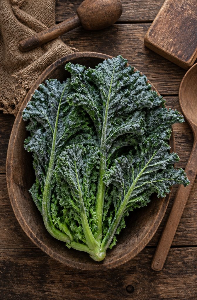 A bunch of mustard greens with vibrant leaves in a garden.